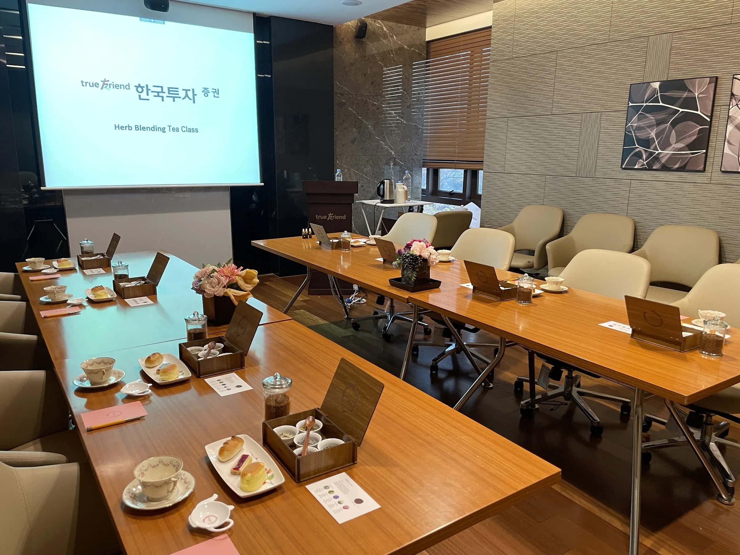 회사티클래스비용 사내 세미나실 테이블 위 티 박스와 디저트 세팅