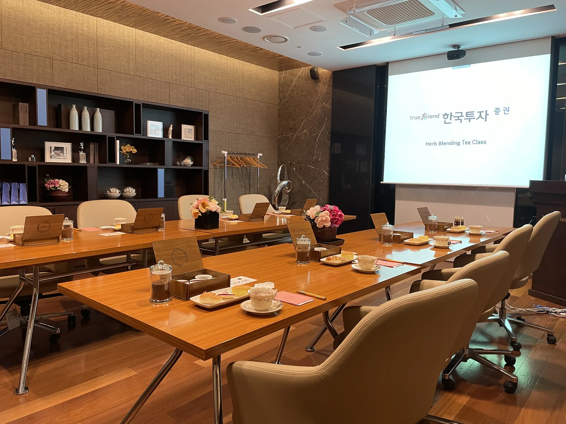 회사티클래스 회의실 스크린 앞 긴 테이블에 놓인 티 세팅
