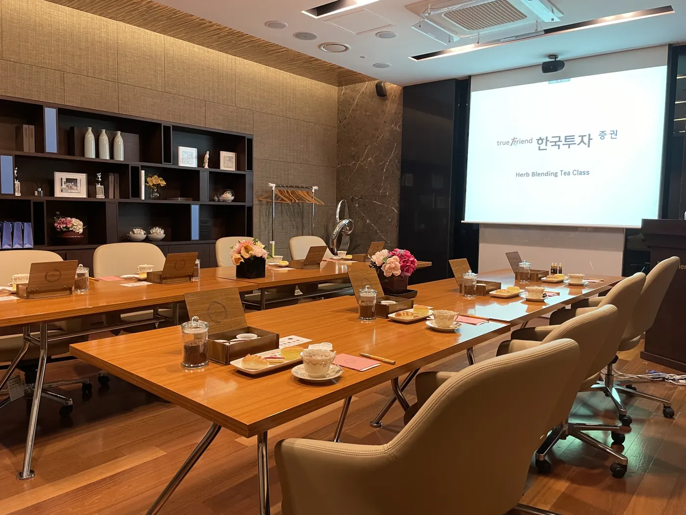 회사티클래스출강 회의실 스크린 앞 긴 테이블에 놓인 티 세팅